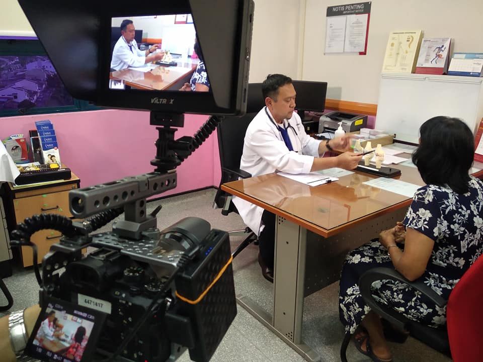 Behind the scenes of a corporate video shoot with a doctor interview and camera monitor