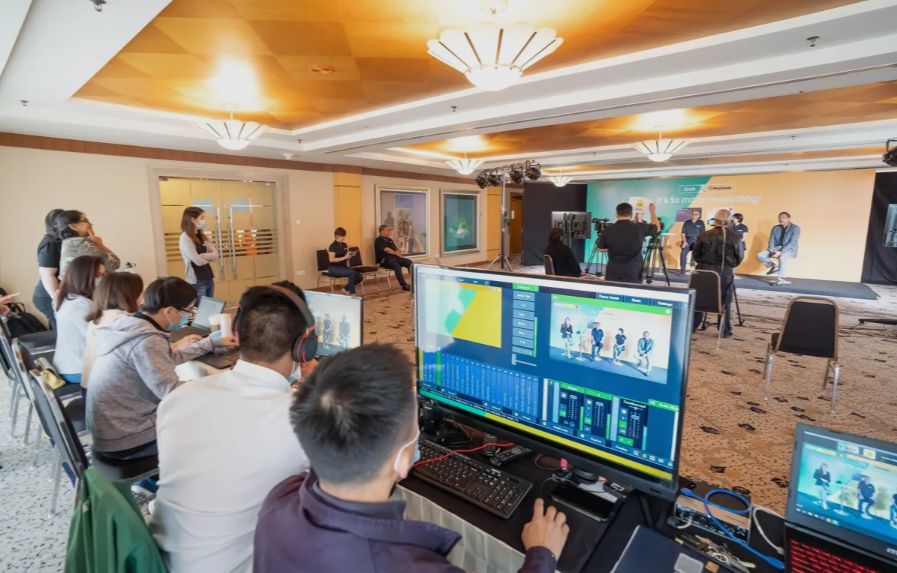 Livestream control room with a vMix monitor operating cameras for a hybrid event in a hotel ballroom